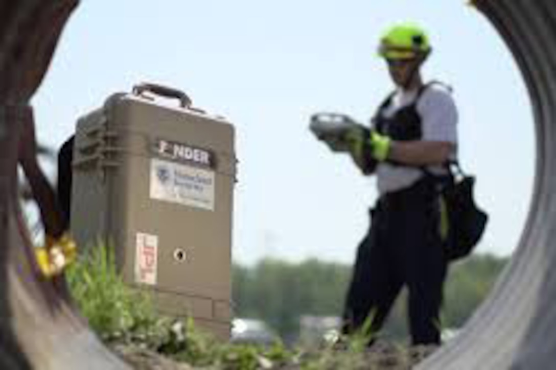 A man stands next to a FINDER device.