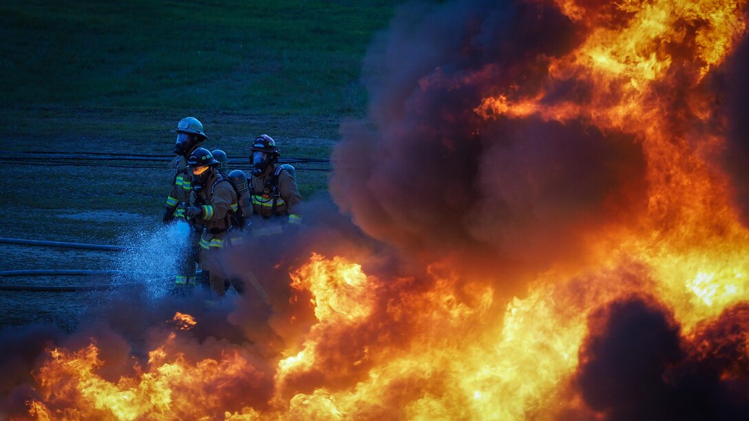 U.S. Air Force firefighters with the 944th Civil Engineer Squadron, Luke AFB, Ariz., 445th Civil Engineer Squadron, Wright Patterson AFB, Ohio, 932nd Civil Engineer Squadron, Scott Air Force Base, Ill., and the 910th Civil Engineer Squadron, Youngstown, Ohio, conduct fire pit training during exercise Patriot Warrior at Sparta/Fort McCoy Airport, Wis., Aug. 20, 2017. Patriot Warrior is an Air Force Reserve training exercise designed to enhance wartime skills in a deployment-style environment and evaluate the ability of units to deploy mobility airlift and agile combat support capabilities in support of joint theater operations. (U.S. Air Force Photo by Staff Sgt. Corban Lundborg)