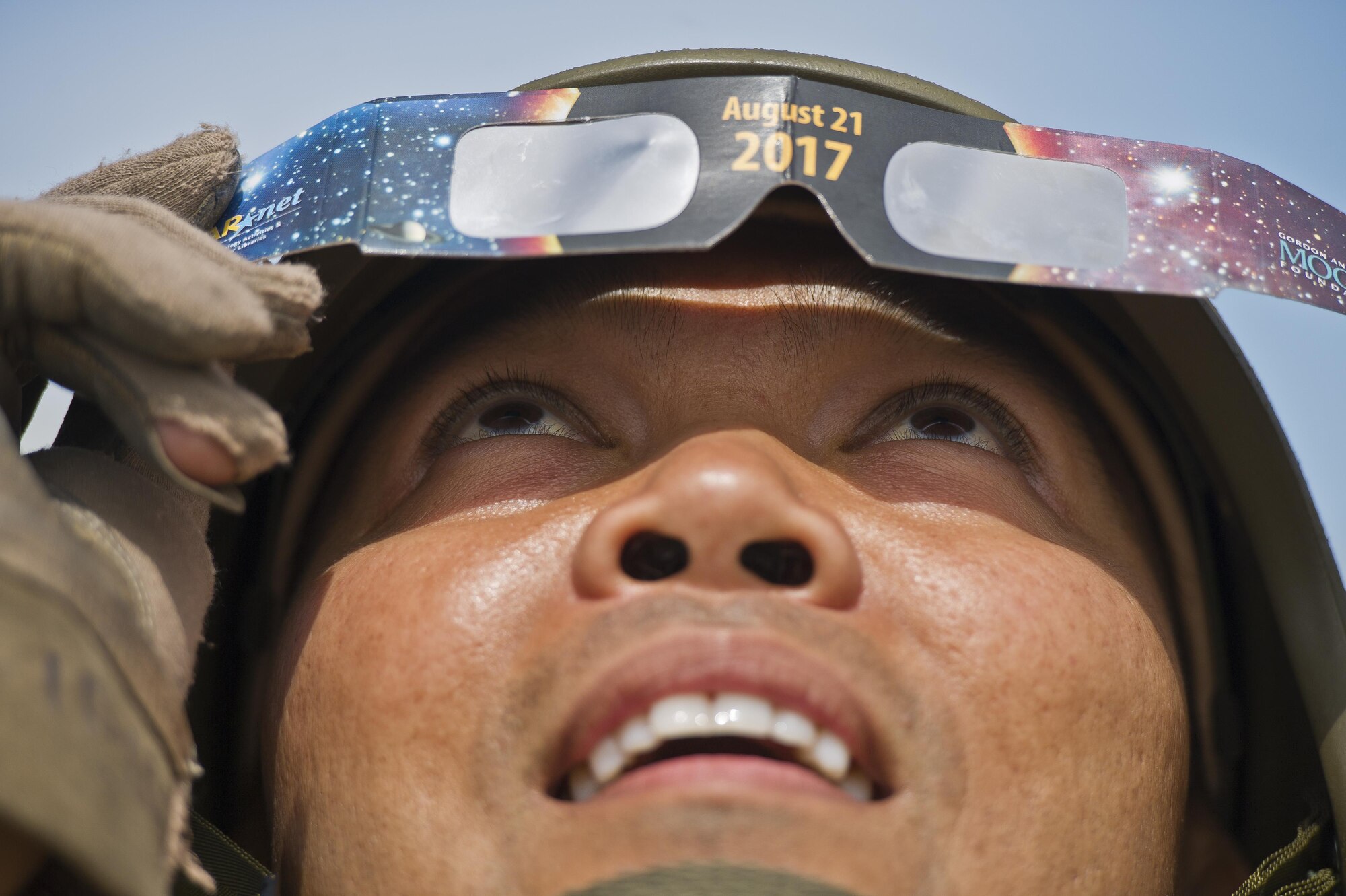 U.S. Air Force Capt. Vincent Alipio, assigned to the 349th Medical Squadron, Travis AFB, Calif., observes through his eclipse glasses as the moon passes in front of the sun during a total solar eclipse at Young Air Assault Strip, Fort McCoy, Wis., Aug. 21, 2017, while participating in exercise Patriot Warrior. More than 600 Reserve Citizen Airmen and over 10,000 soldiers, sailors, Marines and international partners converged on the state of Wisconsin to support a range of interlinked exercises including Patriot Warrior, Global Medic, CSTX, Diamond Saber, and Mortuary Affairs Exercise (MAX).  Patriot Warrior is Air Force Reserve Command's premier exercise, providing an opportunity for Reserve Citizen Airmen to train with joint and international partners in airlift, aeromedical evacuation and mobility support.  This exercise is intended to test the ability of the Air Force Reserve to provide combat-ready forces to operate in dynamic, contested environments and to sharpen Citizen Airmen's skills in supporting combatant commander requirements. ( U.S. Air Force Photo by Tech. Sgt. Efren Lopez )