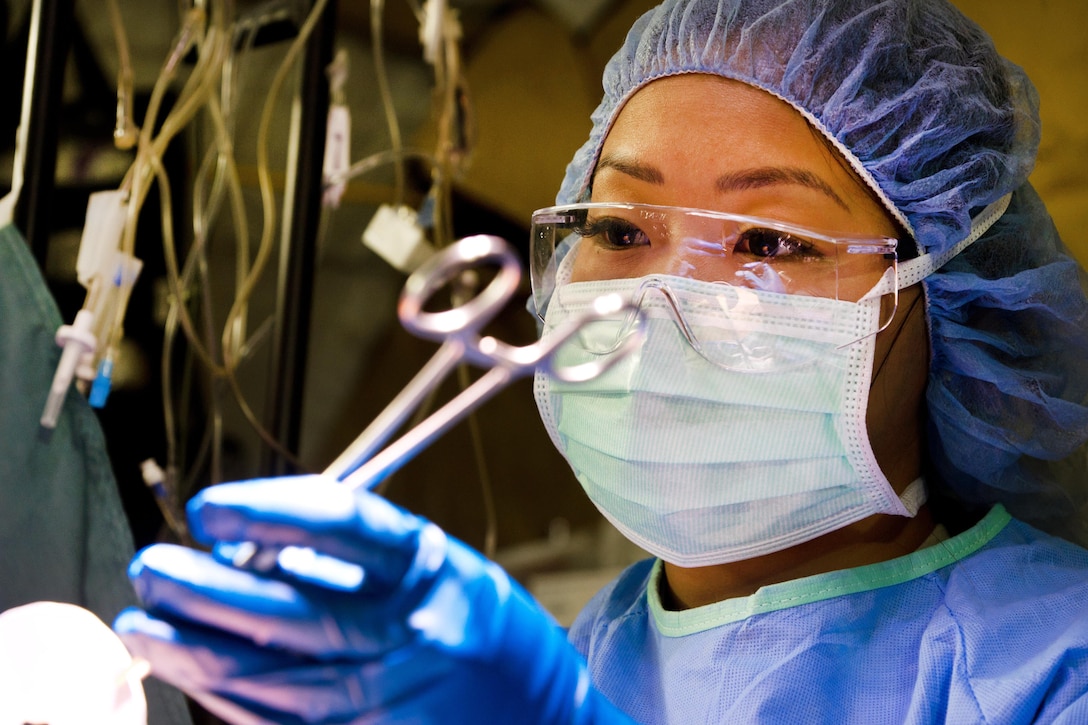 An airman assists during a simulated surgery.