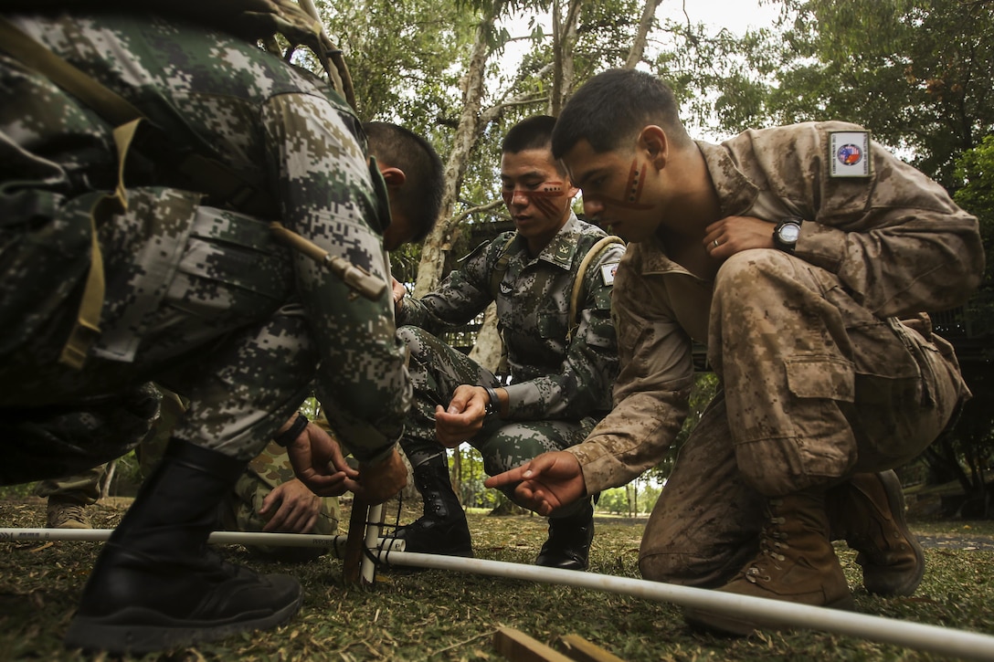 CAIRNS, Australia – U.S. Marine Cpl. Nicolas Villanueva, right, motor transportation operator, Combat Logistics Detachment, Marine Rotational Force Darwin, works with soldiers from the Chinese People’s Liberation Army to build a hut during Indigenous Australian culture classes for Exercise Kowari 2017 Aug. 23, 2017. After the opening ceremony, the Soldiers and Marines also took part in some traditional activities such as boomerang throwing and tribal face painting to introduce those visiting from the US and China to Indigenous Australian culture. Kowari is an annual training activity held in Australia to reinforce trilateral military relationships, trust and co-operation between Australia, China and the United States. (U.S. Marine Corps photo by Sgt. Emmanuel Ramos)
