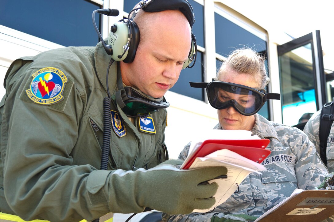 Airmen discuss loading simulated patients onto aircraft.