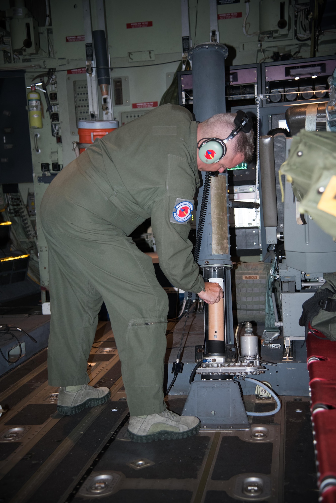 Master Sgt. Erik Marcus, 53rd Weather Reconnaissance Squadron loadmaster, loads a dropsonde into a dropsonde cannon during a flight into Hurricane Harvey Aug. 24, 2017 out of Keesler Air Force Base, Mississippi. (U.S. Air Force photo/Staff Sgt. Heather Heiney)