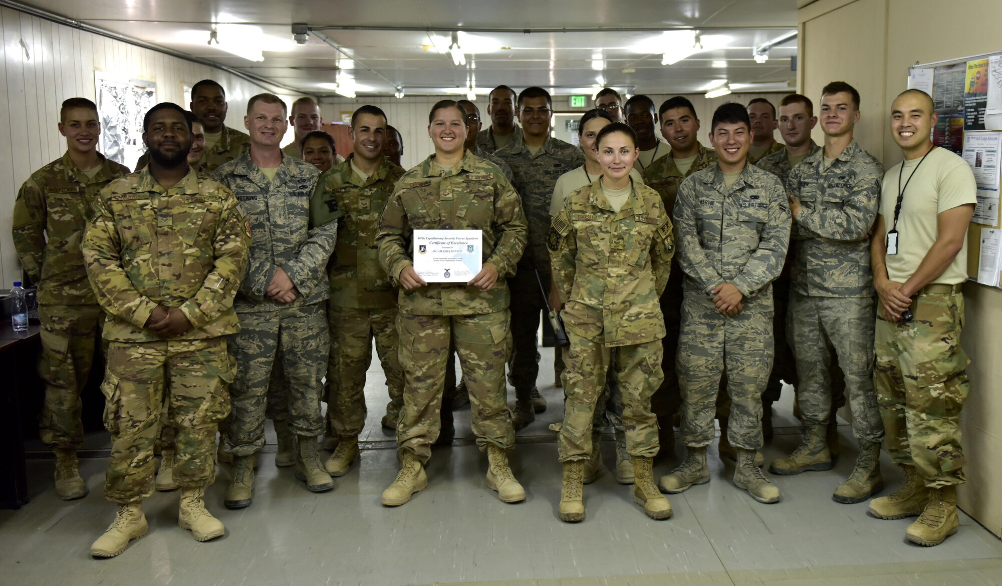 Airman First Class Amanda Danico, 407th Air Expeditionary Squadron force protection member, poses along with her coworkers, August 22, 2017. A1C Danico was awarded for outstanding performance during Security Forces Augmentee Training. Force protection members attend security forces augmentee training as a precaution to assist the 407th Expeditionary Security Forces squadron in case of an Emergency. (U.S. Air Force photo by Senior Airman Timothy D. Dischinat)