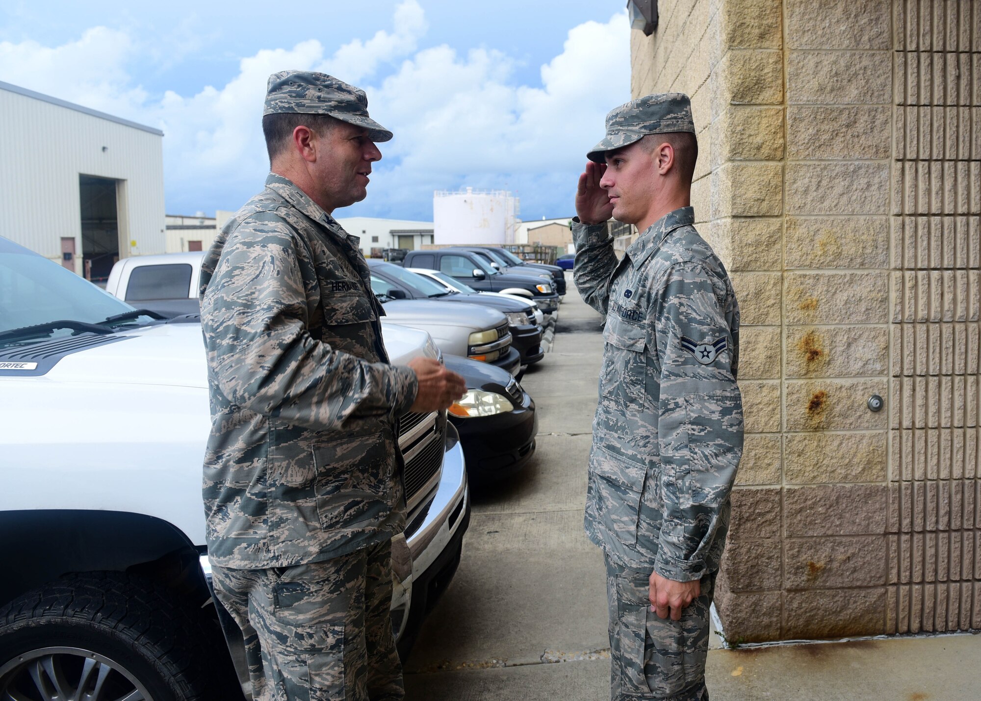 U.S. Air Force Airman 1st Class Michael Conard (right), 325th Maintenance Squadron aerospace ground equipment technician, renders a salute to Col. Michael Hernandez (left), 325th Fighter Wing commander, during the Airman Shadow Program at Tyndall Air Force Base, Fla., Aug. 4, 2017. The program is a 325th FW commander initiative designed to highlight Team Tyndall Airmen, allowing exemplary Airmen the opportunity to show the wing commander what their daily duties entail.