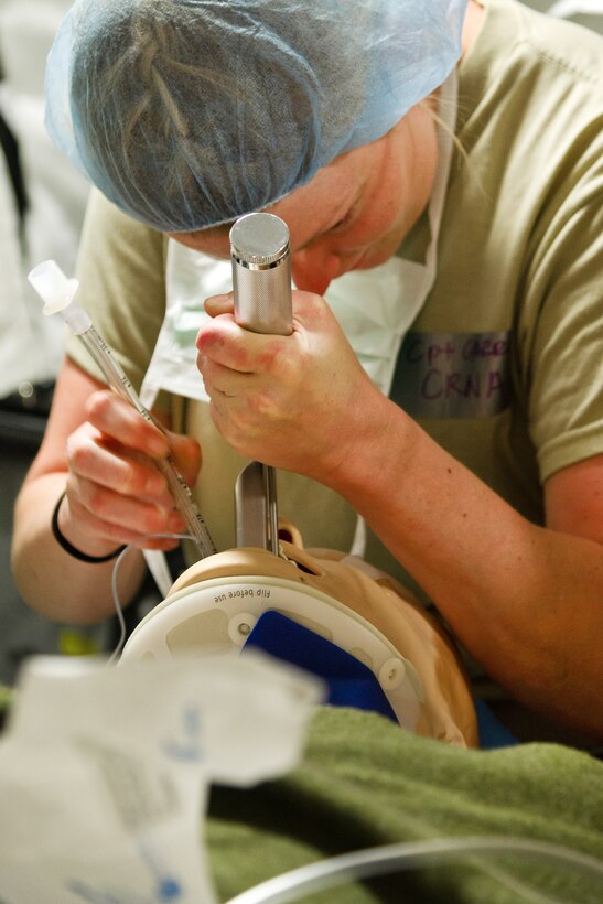 An airman performs a surgical procedure.