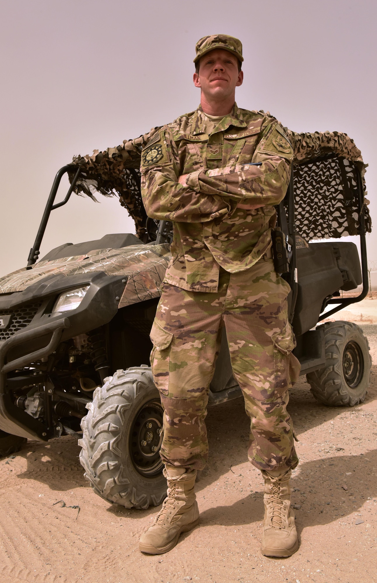 Senior Airman Richard Hillman, 407th Expeditionary Civil Engineer Squadron force protection member, stands beside an all-terrain vehicle August 22, 2017, in Southwest Asia. The all-terrain vehicle allows force protection members to watch over other country nationals from positions a normal vehicle is not able to reach. (U.S. Air Force photo/Senior Airman Timothy D. Dischinat)