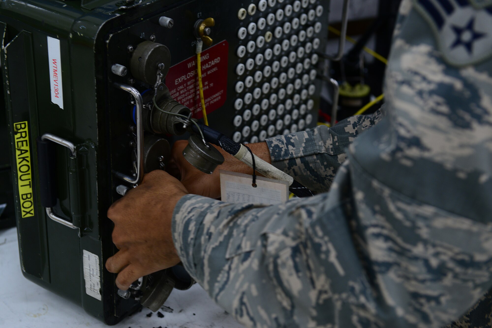 U.S. Air Force Senior Airman Christian Anthony, an electrical and environmental specialist assigned to the 509th Maintenance Squadron, grabs a breakout box to test an overhead lighting control panel at Whiteman Air Force Base, Mo., Aug. 3, 2017.