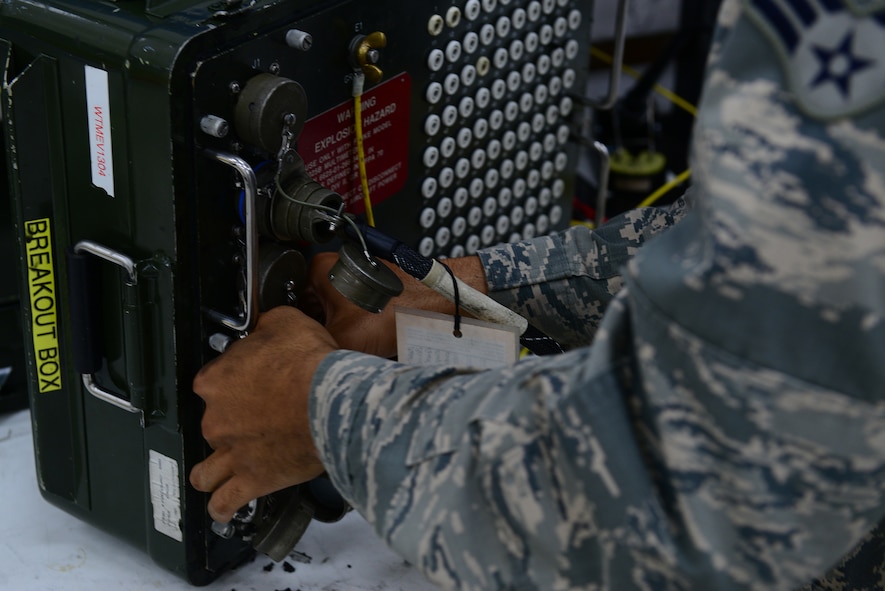 U.S. Air Force Senior Airman Christian Anthony, an electrical and environmental specialist assigned to the 509th Maintenance Squadron, grabs a breakout box to test an overhead lighting control panel at Whiteman Air Force Base, Mo., Aug. 3, 2017.