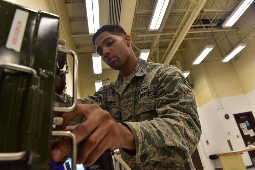 U.S. Air Force Senior Airman Christian Anthony, an electrical and environmental specialist assigned to the 509th Maintenance Squadron, grabs a breakout box to test an overhead lighting control panel at Whiteman Air Force Base, Mo., Aug. 3, 2017.