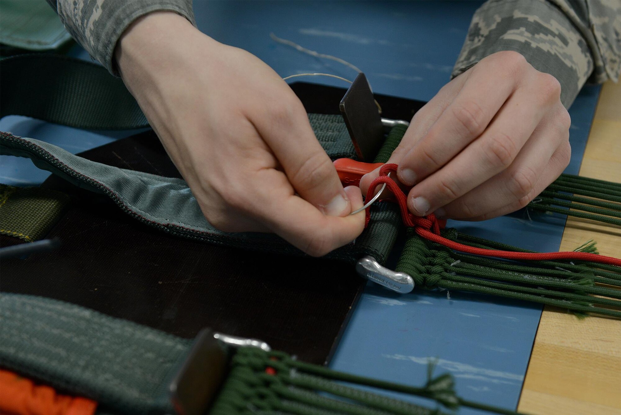 U.S. Air Force Senior Airman Thomas Cadwell, an air-crew flight equipment technician assigned to the 509th Operations Support Squadron, inspects a four-line re-lease at Whiteman Air Force Base, Mo., Aug. 21, 2017. The four-line release is used after the pilot has ejected and needs to steer the parachute to keep it from landing in an unsafe area.