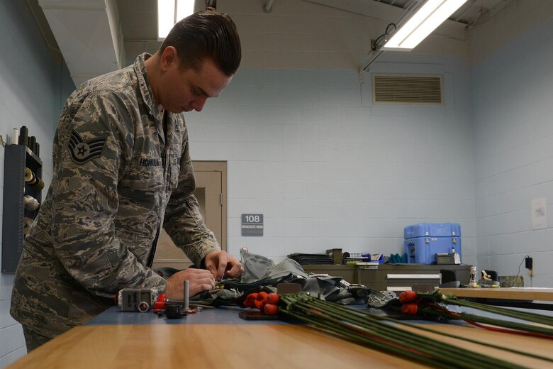U.S. Air Force Staff Sgt. Steven Honkala, an assistant NCO in charge of the aircrew flight equipment survival shop assigned to the 509th Operation Support Squadron (OSS), inspects the emergency beacon of a parachute at White-man Air Force Base, Mo., Aug. 21, 2017. The parachutes the Airmen of the 509th OSS inspect and pack could save a pilot’s life if the pilot needs to eject from an aircraft.