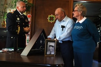 Major Christopher Spencer, 88th Regional Support Command retirement services officer, speaks with Joe Damico and his wife during a presentation of awards earned by Joe's brother, Pfc. George G. Damico, for his service during the Korean War in Cumberland, Wisconsin August 22. Pfc. Damico was killed in action in Korea on September 27, 1950 and his remains were never found.