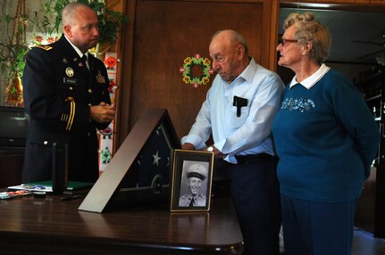 Major Christopher Spencer, 88th Regional Support Command retirement services officer, speaks with Joe Damico and his wife during a presentation of awards earned by Joe's brother, Pfc. George G. Damico, for his service during the Korean War in Cumberland, Wisconsin August 22. Pfc. Damico was killed in action in Korea on September 27, 1950 and his remains were never found.