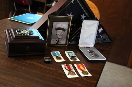 A photograph of Pfc. George G. Damico is surround by the awards he earned for his service in the Korean War. These awards were presented to his surviving family members during a ceremony in Cumberland, Wisconsin August 22. Damico was killed in action in Korea on September 27, 1950.