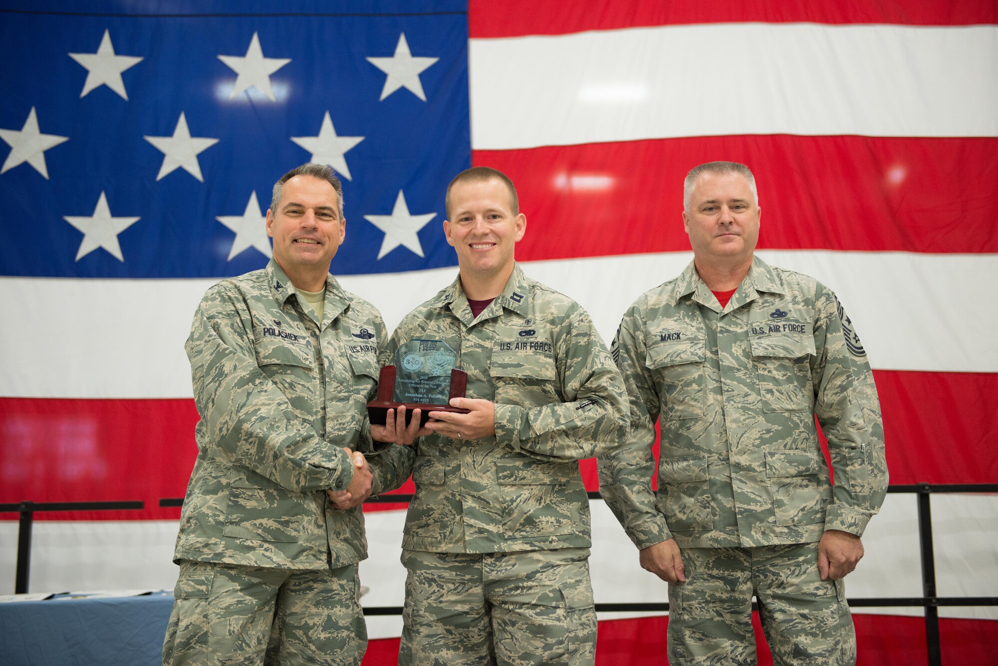 Col. Tony Polashek, 934th Airlift Wing commander (left) presents the AFRC ART Officer of the Year award to Capt. Jon Polos with Command Chief Anthony Mack at the wing commander's call Aug. 13. (Air Force Photo/Tech. Sgt. Trevor Saylor)
