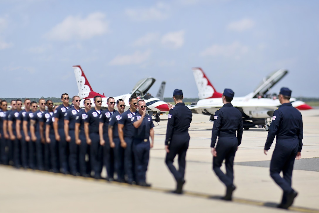 Aircraft pilots and ground crew line up on the tarmac