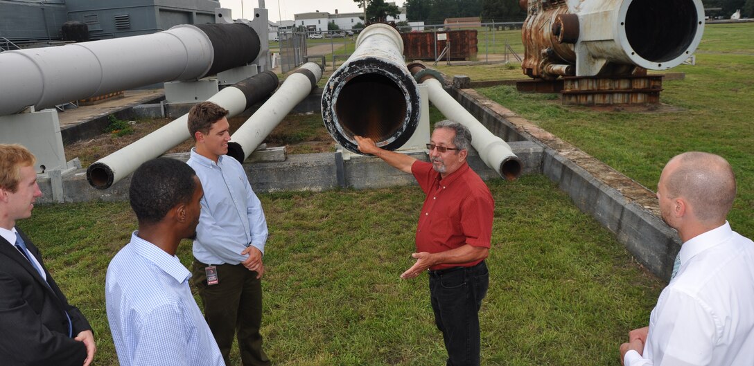 Image: DAHLGREN, Va. (Aug. 21, 2017) - Jim Green, a Potomac River Test Range safety expert, recounts the history of the Navy's 16 inch gun barrel for Science, Mathematics & Research for Transformation (SMART) Scholars during their tour of the Naval Surface Warfare Center Dahlgren Division (NSWCDD) main range. Green explained the inspection process for the 16 inch barrel in the 1940s, comparing it to today's inspections for the 5 inch and 76mm rifled barrel. "The Navy conducts a rigorous inspection process, then live fire testing to ensure the Fleet gun barrels are safe to be fired from a ship," he told the SMART scholars. The Missile Defense Agency sponsored the college students who are among those pursuing a degree in, or closely related to, science, technology, engineering, and mathematics disciplines through the Department of Defense SMART Scholar program. Students selected for SMART Scholarships are offered internships and a stepping stone to future civilian job opportunities in the federal government.