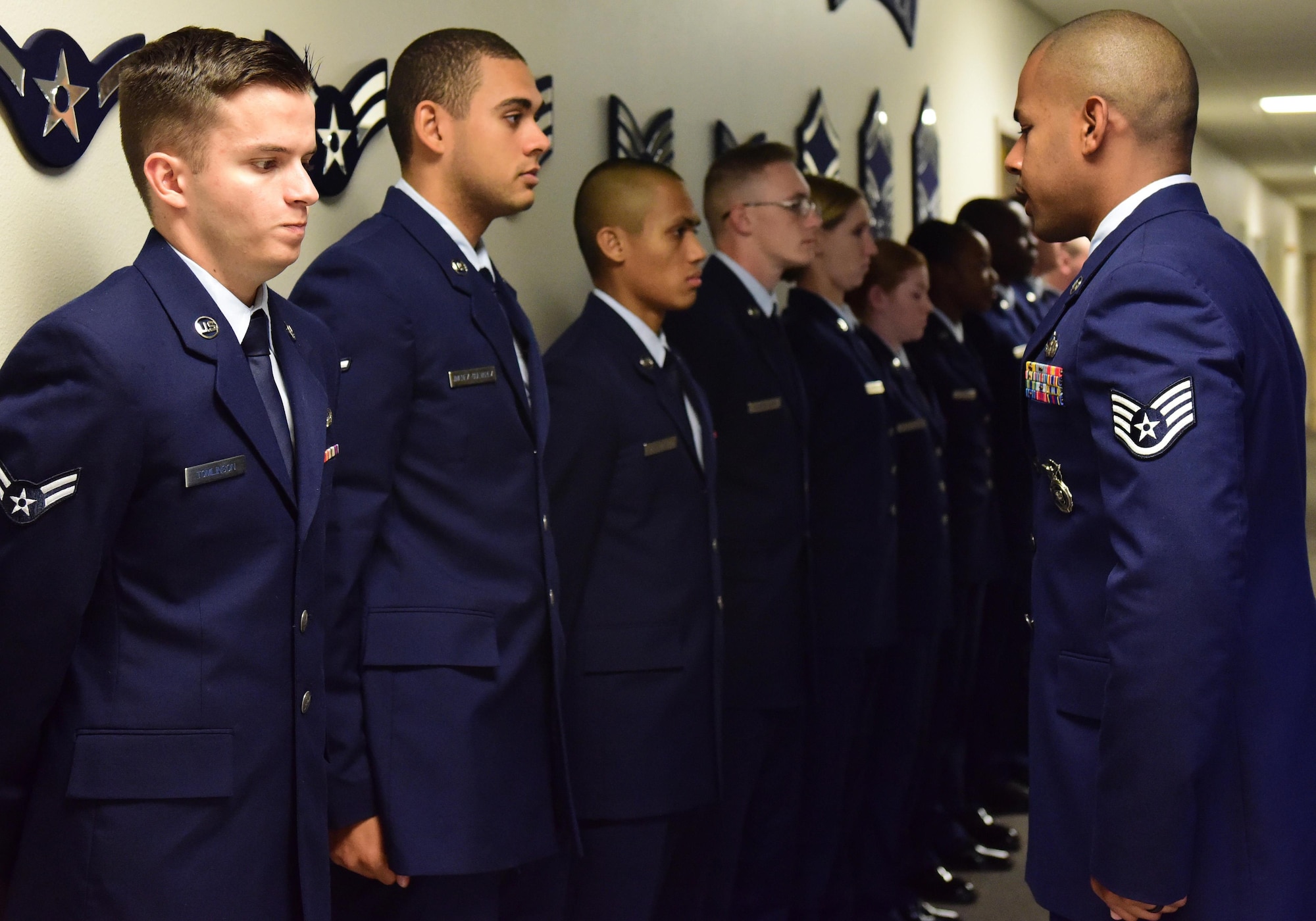 U.S. Air Force Staff Sgt. Bryan Robinson, the First Term Airmen Course (FTAC) NCO in charge, conducts a uniform inspection at Whiteman Air Force Base, Mo., Aug. 7, 2017. Airmen begin the course with a full service dress blues uniform inspection before starting the "Enhancing Human Capital" part of the professionalism training. (U.S. Air Force photo/Staff Sgt. Danielle Quilla)