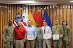 Group facing viewer, some holding certificates