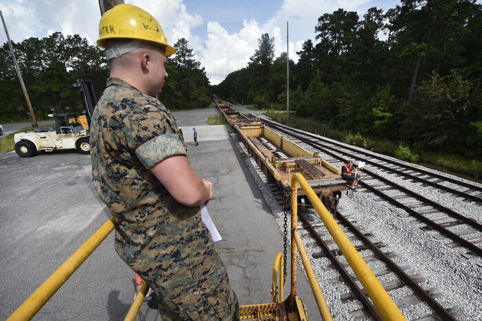 U.S. Marine Cpl. Melvin Willis, Naval Munitions Command Marine Corps Liaison Office member, waits for the arrival of a train transporting munitions during a container download operation at the Joint Base Charleston Weapons Station, S.C., Aug. 21. Marines attached to the NMC’s Marine Corps Liaison Office are responsible for inspecting munitions containers to ensure they are receiving safe quality items during the download. These Marines work alongside NMC civilians and members of the U.S. Air Force 628th Logistics Readiness Squadron to prepare them for transport to their final destination.