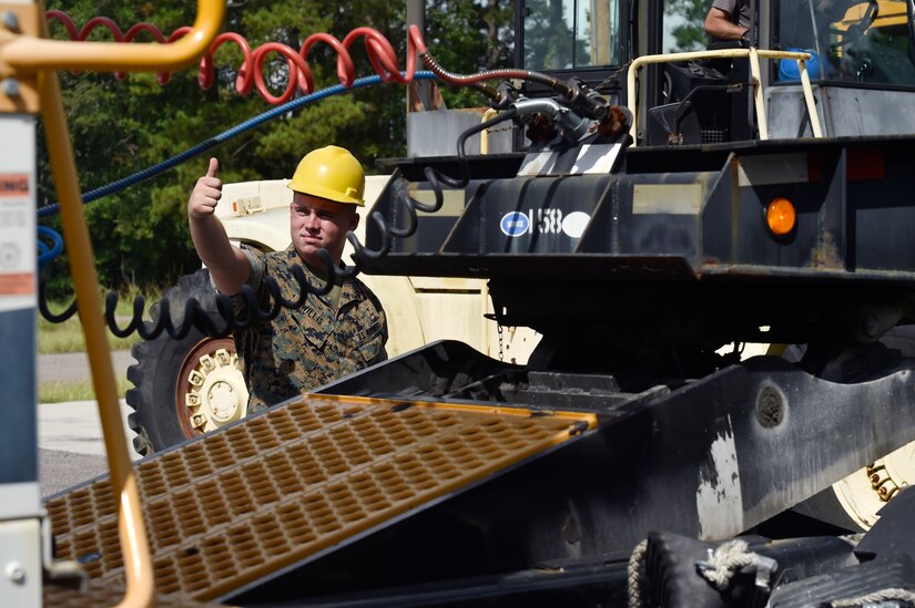 U.S. Marine Cpl. Melvin Willis, Naval Munitions Command Marine Corps Liaison Office member, signals a driver during an inspection of containers carrying munitions at the Joint Base Charleston Weapons Station, S.C., Aug. 21. Marines attached to the NMC’s Marine Corps Liaison Office are responsible for inspecting munitions containers to ensure they are receiving safe quality items during the download. These Marines work alongside NMC civilians and members of the U.S. Air Force 628th Logistics Readiness Squadron to prepare them for transport to their final destination.