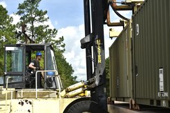 Retired U.S. Marine Mark Lamoureux, Navy Munitions Command Atlantic Unit Charleston marine prepositionary force work supervisor, downloads a munitions container during a download and inspection operation at the Joint Base Charleston Weapons Station, S.C., Aug. 21. NMC civilians, Marines attached to the NMC’s Marine Corps Liaison Office and members of the 628th Logistics Readiness Squadron worked together to download and inspect 76 munitions containers with an eventual destination to U.S. Marines downrange.