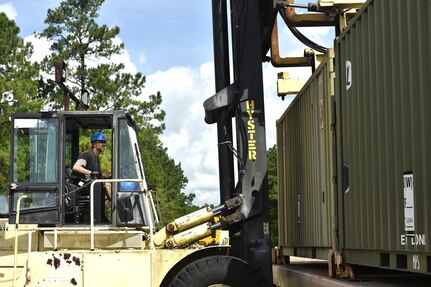 Retired U.S. Marine Mark Lamoureux, Naval Munitions Command marine prepositionary force work supervisor, downloads a munitions container during a download and inspection operation at the Joint Base Charleston Weapons Station, S.C., Aug. 21. NMC civilians, Marines attached to the NMC’s Marine Corps Liaison Office and members of the 628th Logistics Readiness Squadron worked together to download and inspect 76 munitions containers with an eventual destination to U.S. Marines downrange.