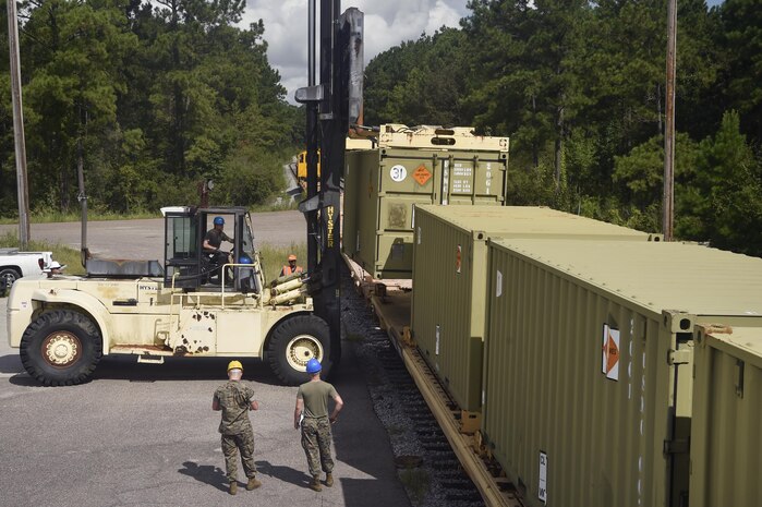 Members of the Naval Munitions Command and U.S. Air Force 628th Logistics Readiness Squadron work together to download and inspect munitions containers at Joint Base Charleston’s Naval Weapons Station Aug. 21. Marines attached to the NMC’s Marine Corps Liaison Office inspect munitions containers that arrive at the weapons station to ensure their quality and safety before being transported to their final destination. Members of the 628th LRS coordinate with a U.S. Navy train conductor to ensure the munitions are safely moved from the train to another facility in preparation for transport to their final destination. (U.S. Air Force photo by Staff Sgt. Christopher Hubenthal)