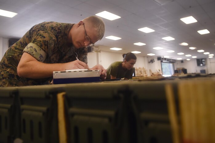 U.S. Marine Sgt. Nathan Smothers, Naval Munitions Command Marine Corps Liaison Office member, records inventory information during a munitions inspection at the Joint Base Charleston Weapons Station, S.C., Aug. 23. Marines attached to the NMC’s Marine Corps Liaison Office are responsible for inspecting munitions containers to ensure they are receiving safe quality items during the download. These Marines work alongside NMC civilians and members of the U.S. Air Force 628th Logistics Readiness Squadron to prepare them for transport to their final destination.
