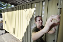 U.S. Marine Sgt. Karissa Greer, Navy Munitions Command Atlantic Unit Charleston Marine Corps Liaison Office member, takes informational placards off of unloaded munitions containers during an inventory inspection at the Joint Base Charleston Weapons Station, S.C., Aug. 23. Marines attached to the NMC’s Marine Corps Liaison Office are responsible for inspecting munitions containers to ensure they are receiving safe quality items during the download. These Marines work alongside NMC civilians and members of the U.S. Air Force 628th Logistics Readiness Squadron to prepare them for transport to their final destination. (U.S. Air Force photo by Staff Sgt. Christopher Hubenthal)