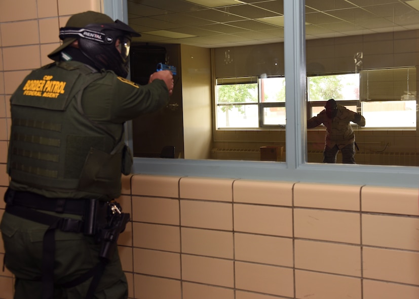 A U.S. Customs and Border Protection agent apprehends his target through a classroom window during active-shooter training at Carl Ben Eielson Elementary School Aug. 9, 2017, on Grand Forks Air Force Base, N.D. Those who participated in the training were given simulation weapons that shot rounds filled with washable paint. (U.S. Air Force photo by Airman 1st Class Elora J. Martinez)