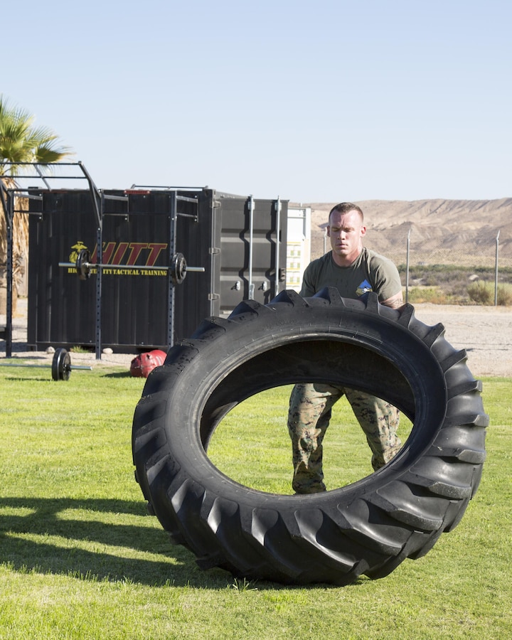 Gunnery Sgt. Justing Kratzer, radio and maintenance chief, flips a tractor tire as part of his High Intensity Tactical Training (HITT) at Sorensen Field aboard Marine Corps Logistics Base Barstow, Calif. Aug. 18.