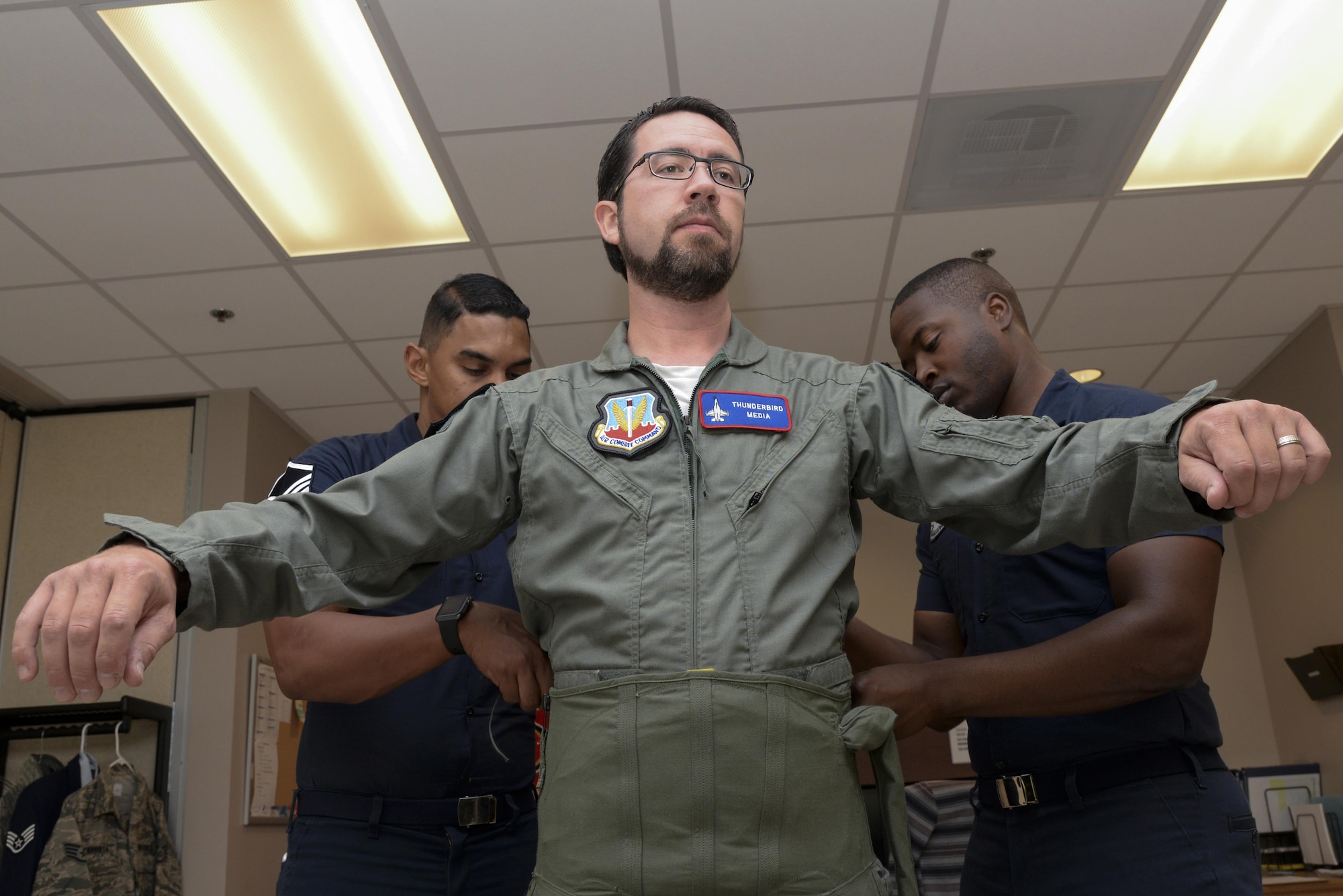 Master Sgt. Paul Rosales and Staff Sgt. Jasper Roberts, U.S.A.F. Thunderbirds aircrew flight equipment technicians, fit Andrew Jackson, radio host for 88.7 The Bridge, for a G-suit in preparation for a media flight Aug. 25, 2017, during the Thunder Over Dover Open House Family Day at Dover Air Force Base, Del. During his flight, Jackson experienced a maximum of 9.2 g’s of force, necessitating the specialized suit to maintain consciousness during the flight. (U.S. Air Force photo by Staff Sgt. Aaron J. Jenne)
