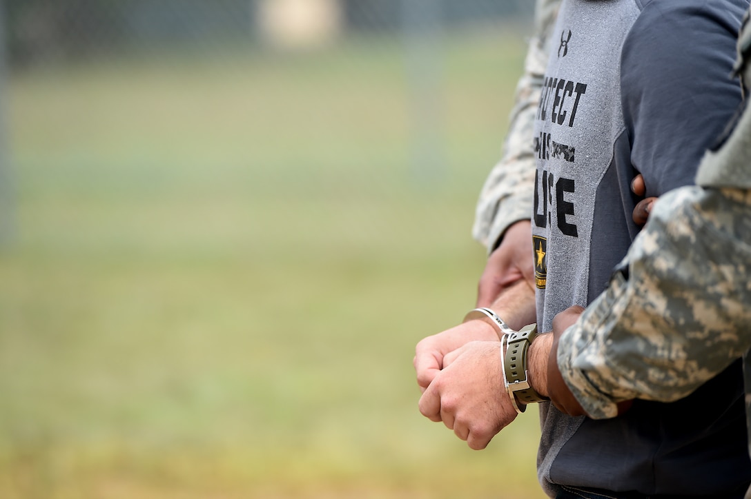 The hands of a detainee are shackled with hand-irons while entering an entry control point in a mock detention facility during Combat Support Training Exercise 86-17-02 at Fort McCoy, Wisconsin, from August 5 – 25, 2017.