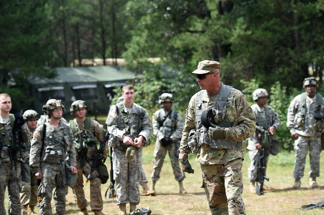Army Reserve Chief Warrant Officer 5 Eric Nordy, left, Command Chief Warrant Officer, 85th Support Command, speaks with Soldiers from the 360th Chemical Company after a simulated base attack during Combat Support Training Exercise 86-17-02 at Fort McCoy, Wisconsin, from August 5 – 25, 2017.