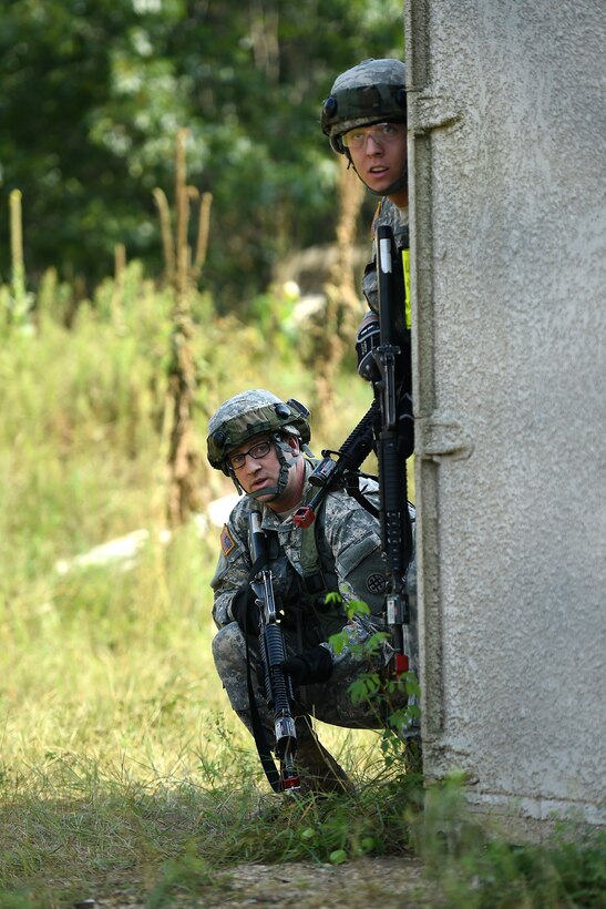 Army Reserve Soldiers assigned to the 693rd Quartermaster Company, Bell, California, check around a corner while moving through a mock village during Combat Support Training Exercise 86-17-02 at Fort McCoy, Wisconsin, from August 5 – 25, 2017.