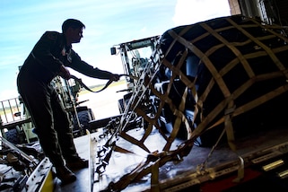 Air Force Staff Sgt. Todd Johnson secures a pallet of equipment in preparation for rescue operations.