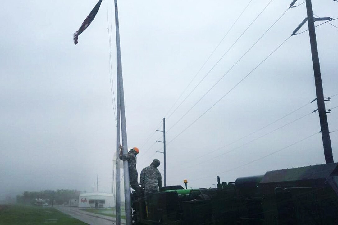 Texas Army National Guardsmen attempt to recover an American flag.