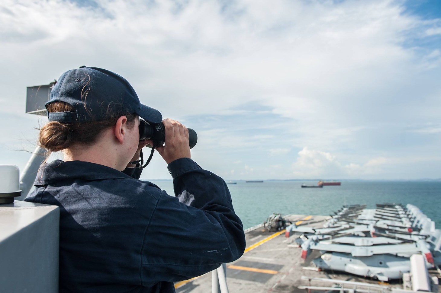 Seaman Megan Stapp, a native of Chattanooga, Tenn. stands watch aboard the amphibious assault ship USS America (LHA 6) as it departs Singapore. America provided initial assistance to the Arleigh Burke-class guided-missile destroyer USS John S. McCain (DDG 56) following a collision on Aug. 21.
