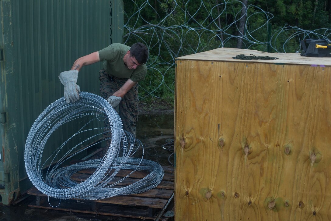 U.S. Marine Corps Lance Cpl. Samual F. Interlichia, a cyber network operator with 26th Marine Expeditionary Unit (MEU), organizes concertina wire during Realistic Urban Training (RUT) at Marine Corps Outlying Field Camp Davis-South, N.C., Aug. 16, 2017.
