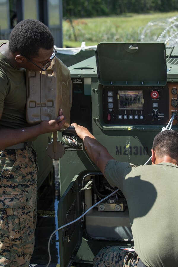 U.S. Marine Corps Cpl. Kennedy A. Rivers, left, a supply and administrative clerk, and Cpl. Miguel A. Rivera, a food service specialist, both with the 26th Marine Expeditionary Unit (MEU), provide diesel gasoline to power a generator during Realistic Urban Training (RUT) at Marine Corps Outlying Field Camp Davis-South, N.C., Aug. 16, 2017. RUT allows the 26th MEU Marines to gain operational experience working as a unit in an urban environment as preparation for an upcoming deployment at sea. (U.S. Marine Corps photo by Lance Cpl. Jered T. Stone)