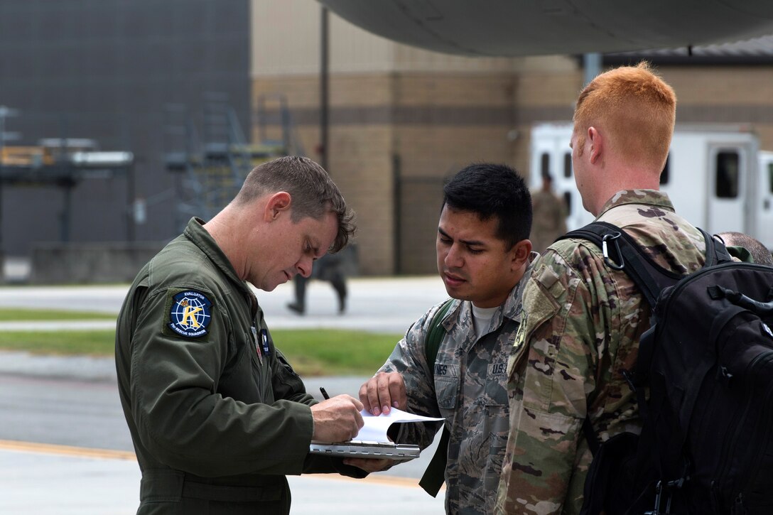 Airman verify passenger information before boarding an HC-130J Combat King II aircraft that was traveling to Texas for Hurricane Harvey relief.