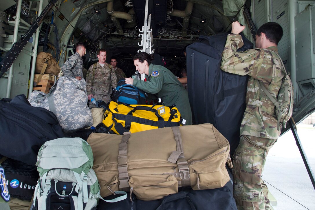 Airmen organize bags before securing them on a HC-130J Combat King II aircraft that was traveling to Texas for  Hurricane Harvey relief.