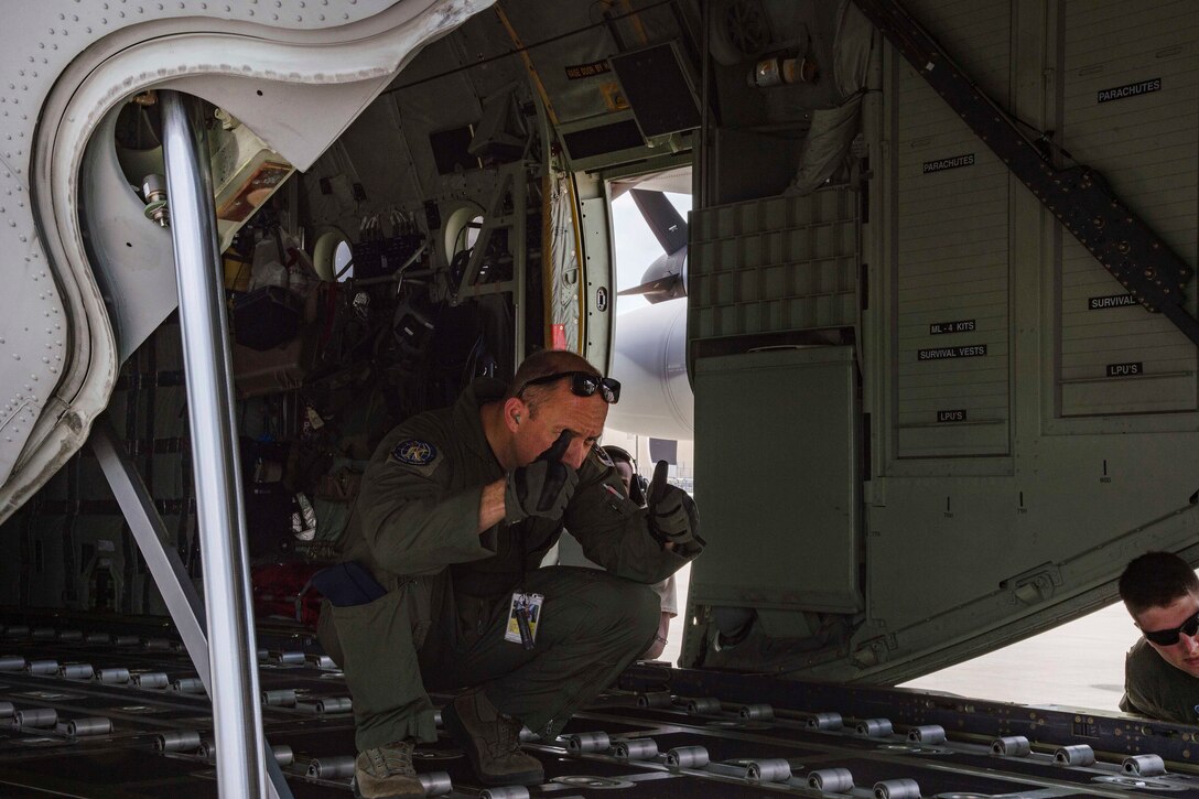 An Airman guides a forklift carrying cargo onto an HC-130J Combat King II aircraft.