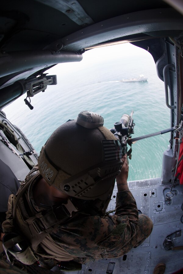 A U.S. Marine with the Maritime Raid Force, 26th Marine Expeditionary Unit (MEU), holds an aerial sniper position utilizing an M110 Semi-Automatic Sniper System aboard a U.S. Navy MH-60S Seahawk helicopter with Helicopter Sea Combat Squadron 28 during visit, board, search and seizure training during Realistic Urban Training (RUT) at Camp Davis Training Area - South, N.C., Aug. 20, 2017. RUT provides the MEU an opportunity to train in unfamiliar environments in preparation for an upcoming deployment at sea. (U.S. Marine Corps photo by Lance Cpl. Alexis C. Schneider)