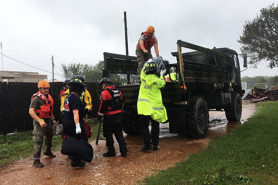 Texas National Guardsmen work with emergency responders in assisting residents affected by Hurricane Harvey flooding.