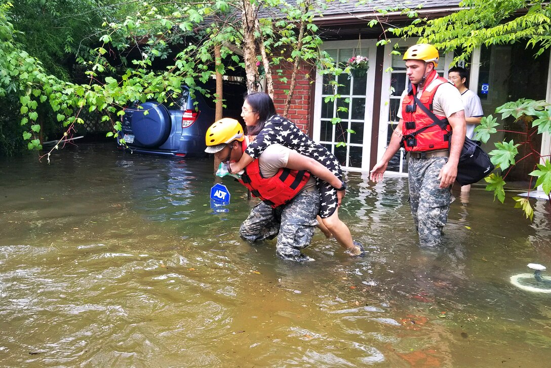 A Texas National Guardsman carry’s a residents from her home affected by flooding caused by Hurricane Harvey.