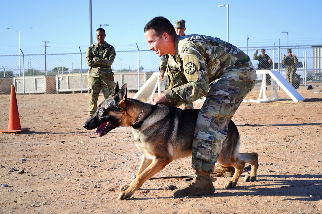 Army Sgt. Gabriel Garcia prepares to release his military working dog to demonstrate a controlled aggression technique