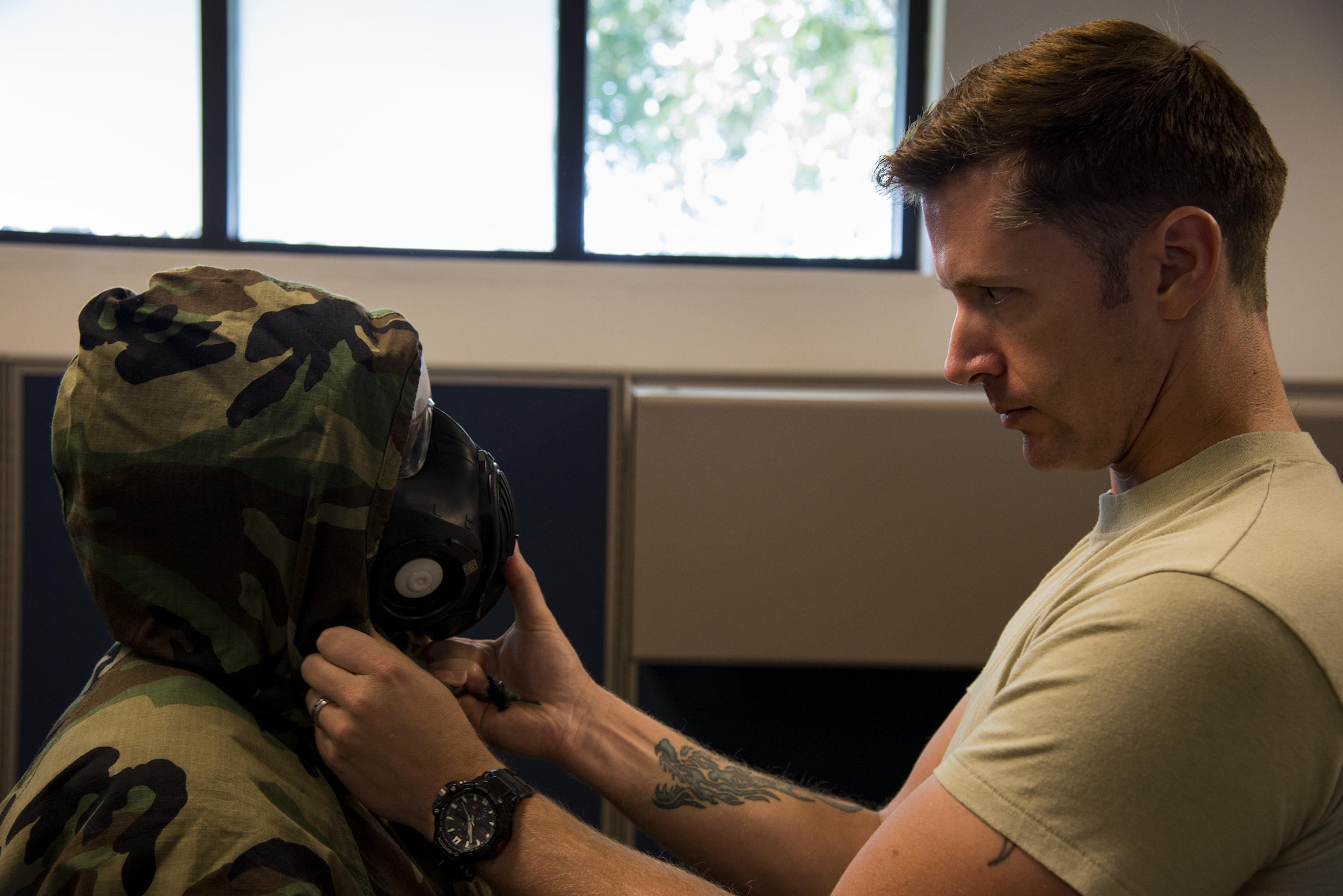 Tech. Sgt. Kelly Dawson, 347th Operations Support Squadron NCO in charge of aircrew flight equipment, right, adjusts Airman 1st Class Shelby Staple, 347th OSS AFE technician’s, mask during Aircrew Contamination Control Area training, Aug. 24, 2017, at Moody Air Force Base, Ga. ACCA training teaches aircrew how to remove and properly handle any contamination on their gear. (U.S. Air Force photo by Airman 1st Class Erick Requadt)